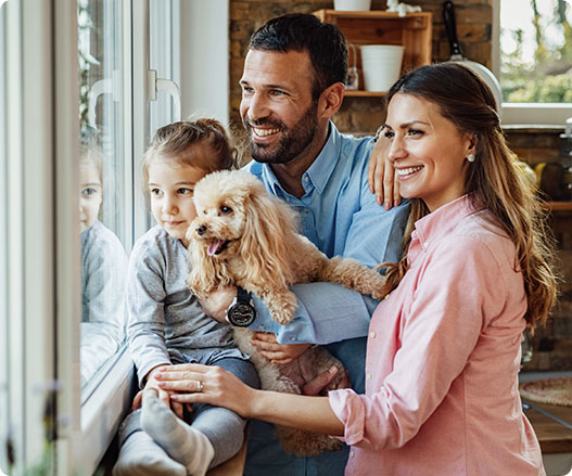 family with dog smiling looking out of window